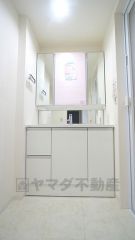 明るく清潔感のある色調で纏められた洗面室は、機能性に富んだ三面鏡の洗面台と採光窓が特徴です。通気性もよく、洗濯機置場も完備し、家事の動線も配慮されたデザインになっております。